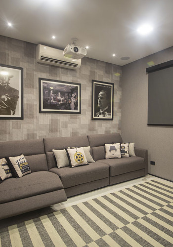 Para equilibrar a acústica, a sala possui estofado de tecido, cortina blackout e tapete