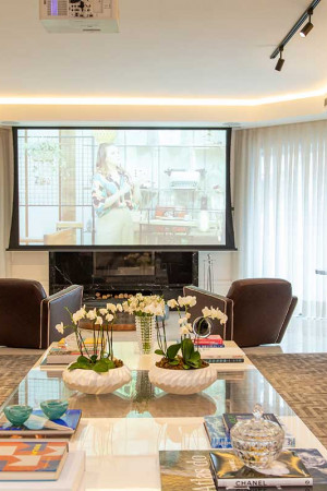 Com 120”, a maior tela do apartamento fica no living, com o projetor pendurado no teto