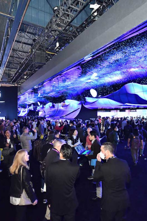 Visitantes da CES diante do portal de entrada no estande da LG, revestido de telas OLED.