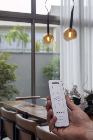 Pelo controle, a família abre e fecha as cortinas motorizadas.