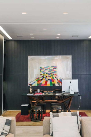 Atrás do home theater fica o home office, com som ambiente (caixas de teto) e boa visão do TV de 65”.