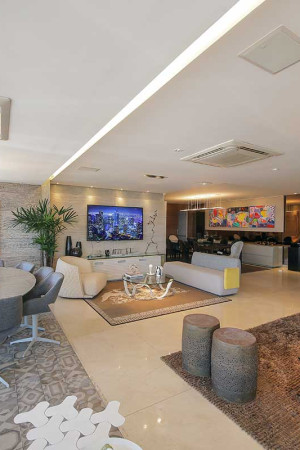 Da integração entre as salas de estar, jantar e varanda, surgiu uma ampla área social com TV de 65” e seis caixas acústicas embutidas no teto.