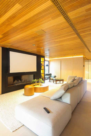 Com 25m2, a maior tela da casa tem 119” e está embutida no teto. Já as caixas acústicas, também de embutir, foram pintadas deixando o ambiente ainda mais discreto.