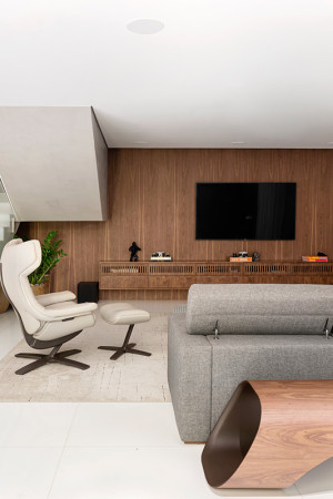 No living do piso térreo, a TV de 75” foi montada em um painel de parede com o mesmo acabamento do</br> móvel baixo.