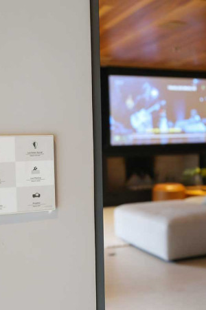Na entrada da casa, o painel de parede personalizado comanda as luzes e outras funções da automação.