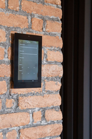 O painel de automação na parede de tijolo dá um tom moderno</br>ao visual rústico.