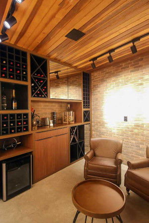 Detalhe da adega, com iluminação pontual e caixas embutidas no</br> teto de madeira.