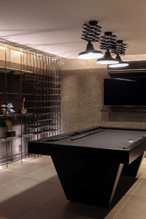 Com acesso pela garagem, a adega ganhou TV de 65”, caixa soundbar e mesa de sinuca.