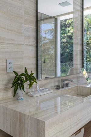 Banheiro da suíte principal: revestimentos em mármore, keypads e tomadas seguindo o mesmo padrão de refinamento.