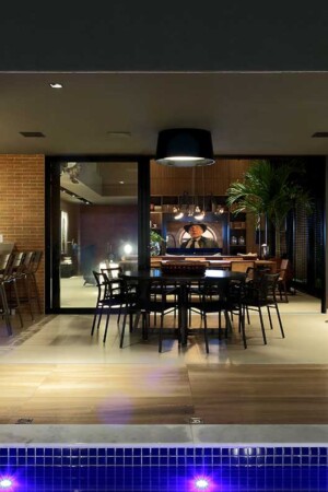 Vista da varanda gourmet, entre a piscina e o home theater, com caixas embutidas no teto.