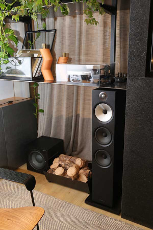 Além das duas caixas torre high-end, há dois subwoofers posicionados um de cada lado da tela.