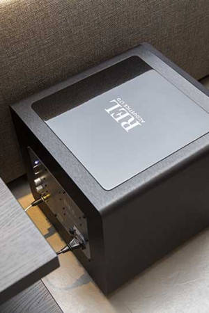 Subwoofer high-end instalado discretamente num canto da sala