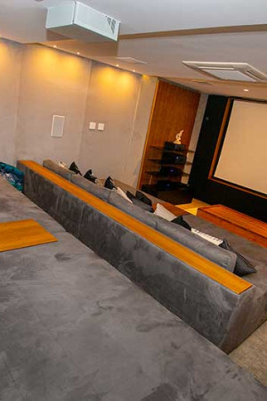 São duas fileiras de poltronas montadas sobre piso em desnível, para melhor visualização da tela.