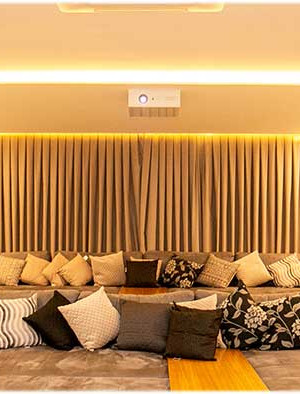 Cortinas acionadas pela automação ajudam a equilibrar a acústica da sala.