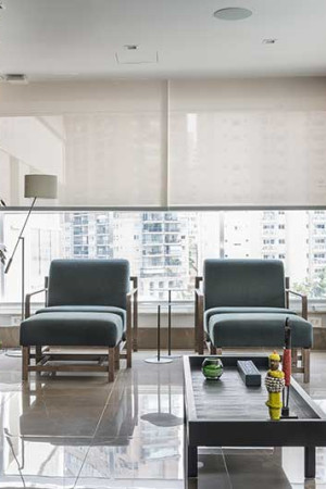 Caixas de teto e cortinas acionadas pelo celular se destacam na varanda com jardim vertical