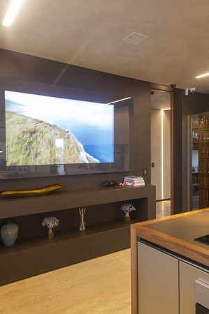 Detalhe da cozinha, com TV montada dentro de um espelho, produzindo interessante efeito visual.