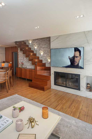A ampla sala de estar, com lareira, ganhou uma TV de 65” </br>para os hóspedes.