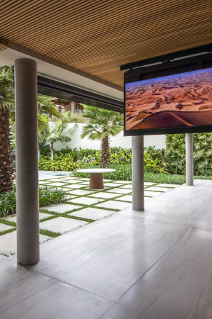 Também na varanda a TV (55”) foi montada num flap: a tela pode girar para ser vista também da cozinha</br> e da piscina.