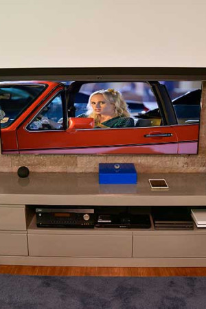 Na sala principal, há duas telas 4K: a de projeção, com 105”, quando desce cobre a TV de 65”.