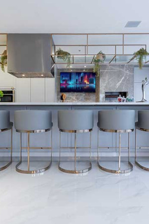 Aqui, vista do amplo espaço gourmet, com TV de 55” montada sobre outro painel de mármore.