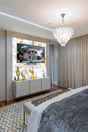 Na suíte, interessante efeito visual no painel que sustenta a TV.