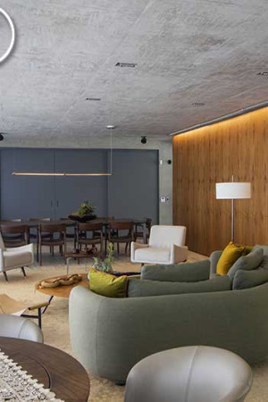 No amplo living, as caixas de teto em formato redondo valorizam o estilo clean do ambiente.