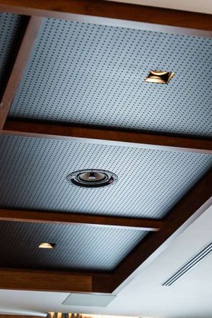 No teto do home theater de 50m2, estão os dutos de climatização central e sete caixas acústicas como esta.