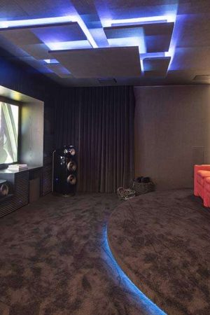 A tela de 120” foi montada num nicho da parede: a decoração em tons escuros otimiza o uso da tela.