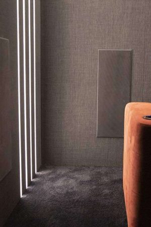 Uma das quatro caixas surround, embutida discretamente na parede, atrás do sofá.