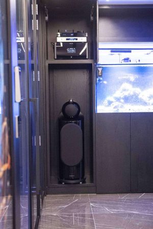 Detalhe de uma das caixas do living, com subwoofer embutido, montadas em nichos do móvel.