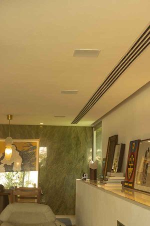 São cinco caixas de teto no living, direcionando os sons para a área do sofá.