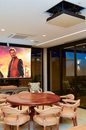 Um dos ambientes da varanda, com tela de 120” e projetor 4K embutidos no teto.