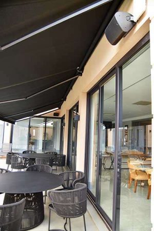 Detalhe da área externa, com caixas do tipo outdoor para sonorizar junto à varanda e a piscina.