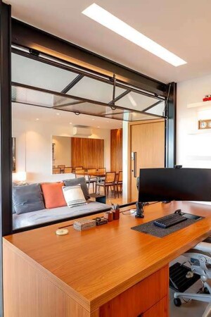 Através desta discreta janela, o home office se integra ao living e ao home theater.