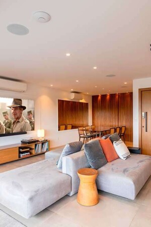 O sofá-ilha no centro do living promove a integração entre home theater, office e varanda.