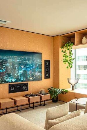 Este é o segundo home theater, com TV de 85” e caixas embutidas no painel de madeira, inclusive o subwoofer.