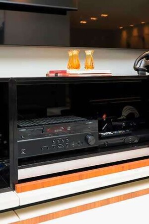 Detalhe do subwoofer montado dentro do móvel, com piso falso, para controlar as vibrações.