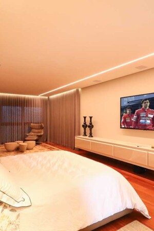 Na suíte, outro home theater, com TV de 75” e caixas embutidas no gesso, alimentadas por um receiver independente.