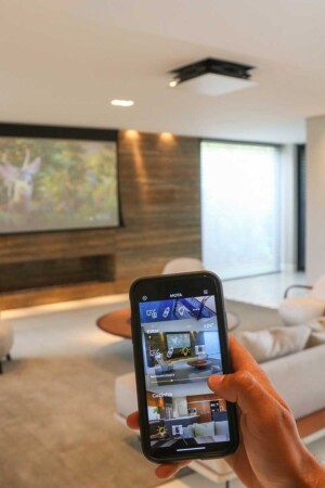 Por um app de celular, os moradores visualizam todos os ambientes mesmo quando estão fora de casa.