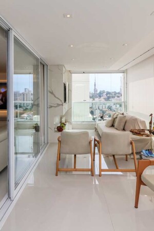 A sala de home theater é integrada à varanda, com separação por divisória e cortinas.