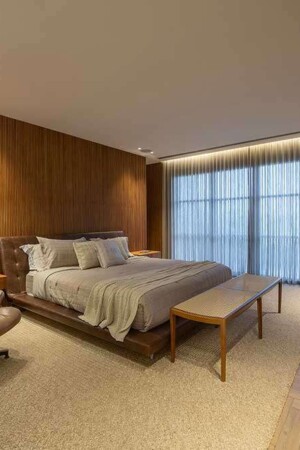 Na suíte, com paredes e piso de madeira, foi usado forro de gesso para embutir luminárias e caixas acústicas.