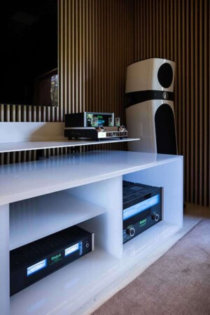 Móvel em tom claro abriga os equipamentos; ao fundo, uma das torres de alto padrão.